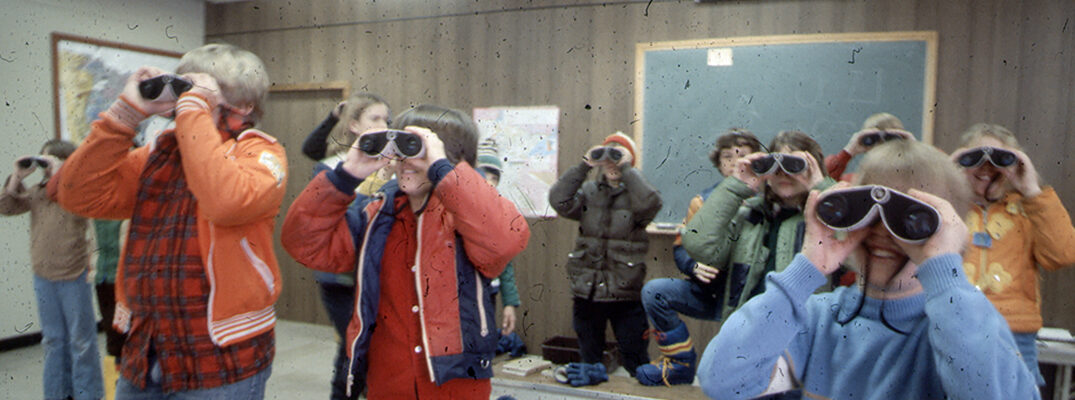 Students using binoculars in classroom
