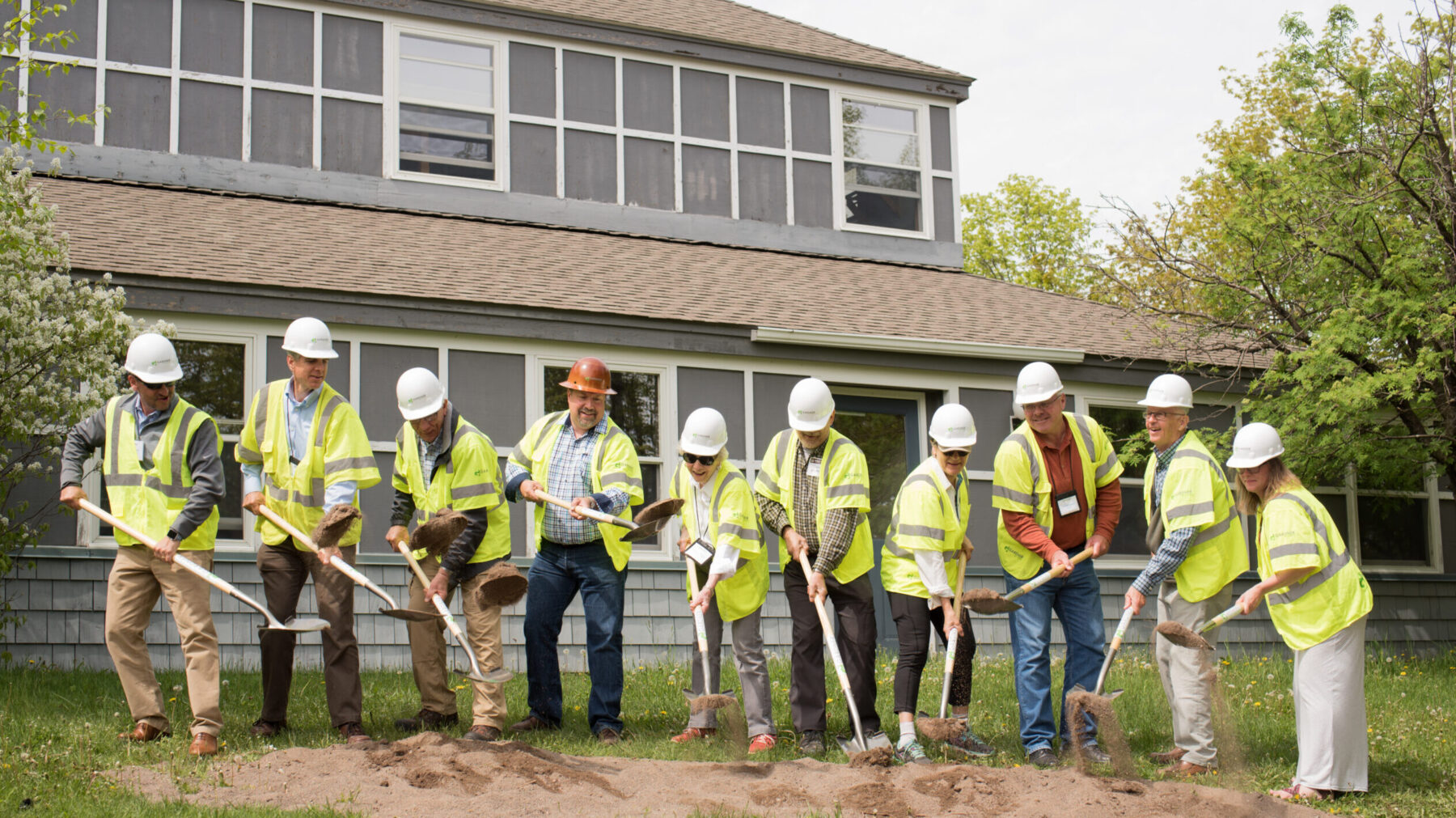 Group Wearing Construction Outfits Holding Shovels