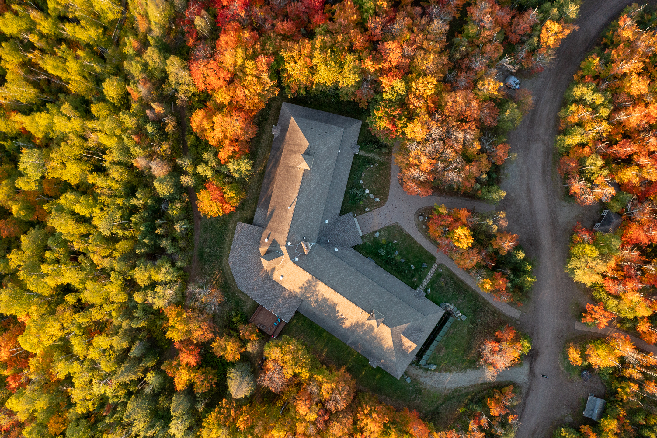 Drone View of Building in Forest With Red and Yellow Leaves