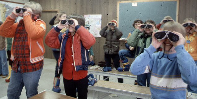 Students using binoculars in classroom
