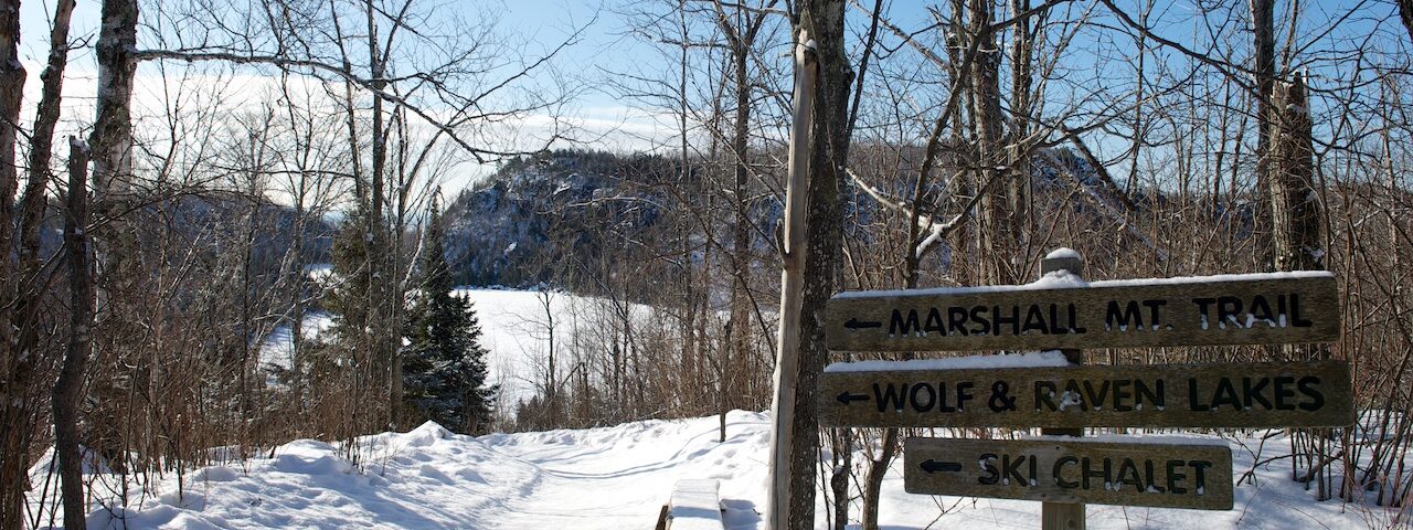 Trail signs to Marshall Mt. Wolf & Raven Lakes, ski chalet at Wolf Ridge