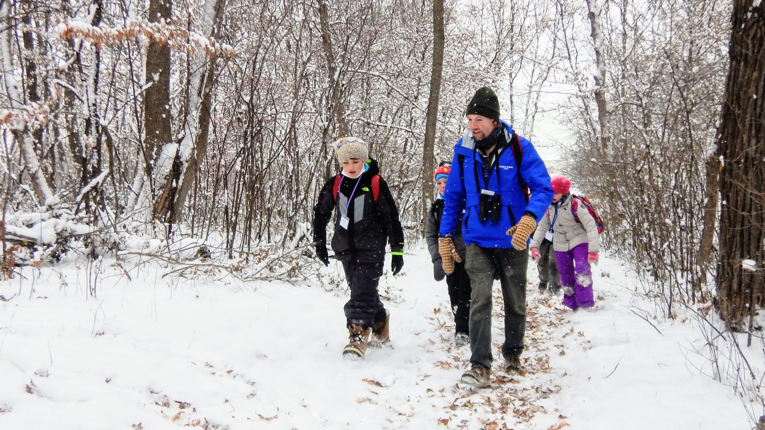 Students and teacher on walk in snowy woods