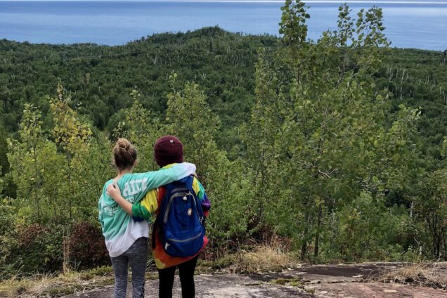 Student hugging near Lake Superior at Wolf Ridge